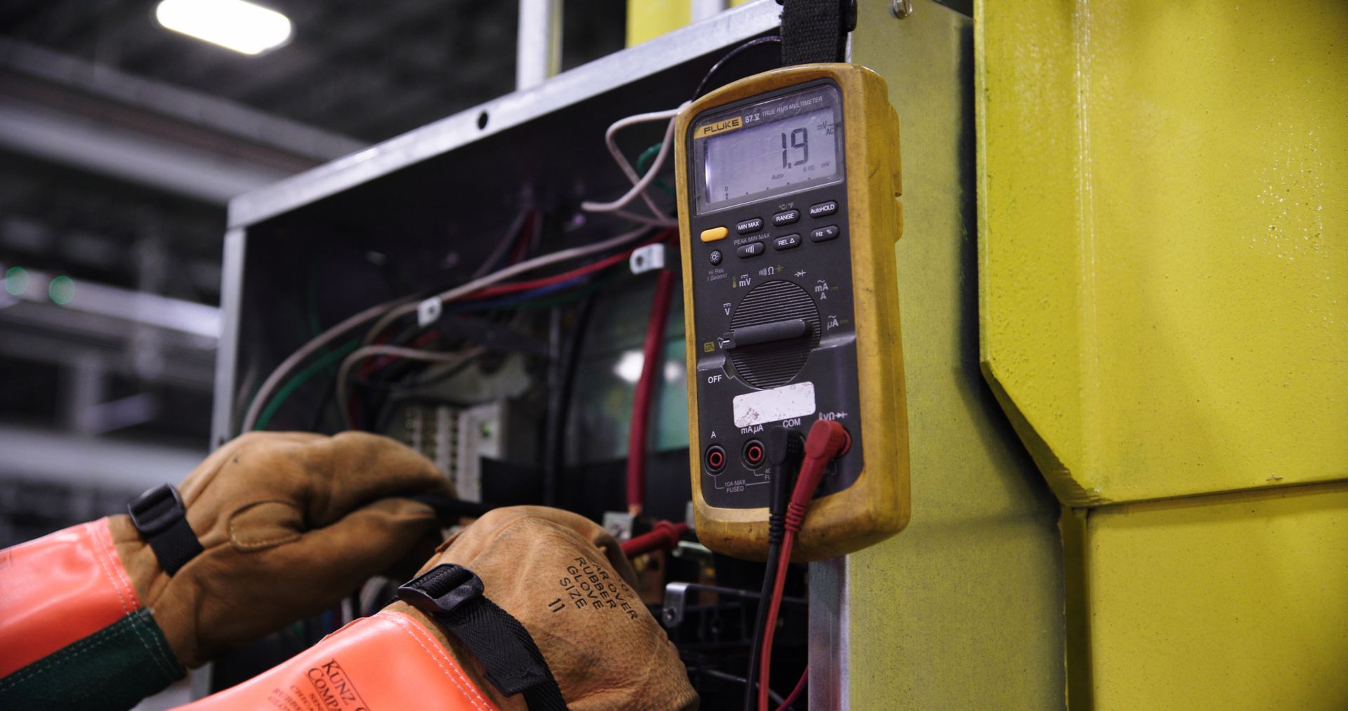 Specialistas tikrina pastato elektros įrangą ir atlieka planinę elektros sistemos priežiūrą.